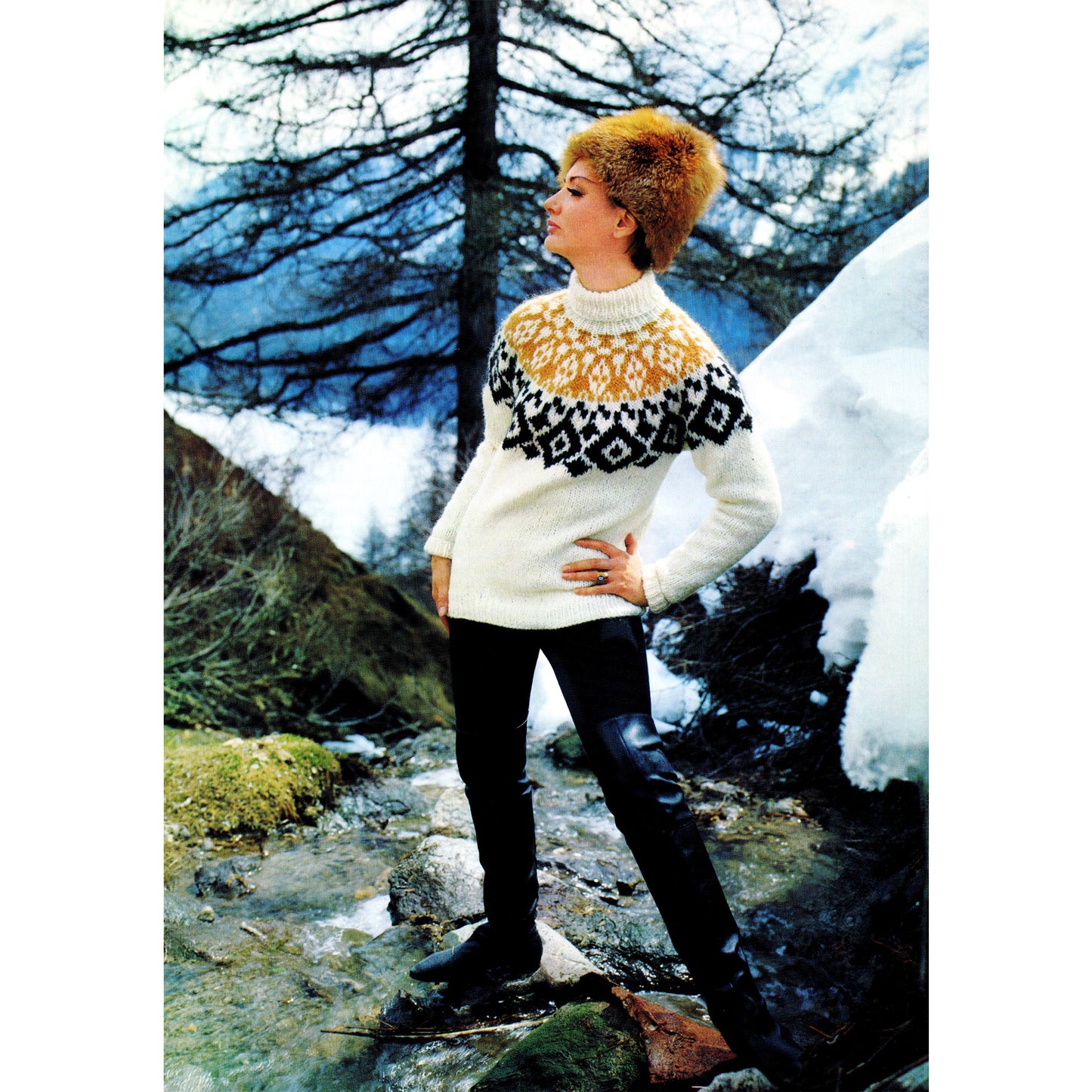 Woman wearing a patterned sweater with a circular yoke, standing in a snowy landscape