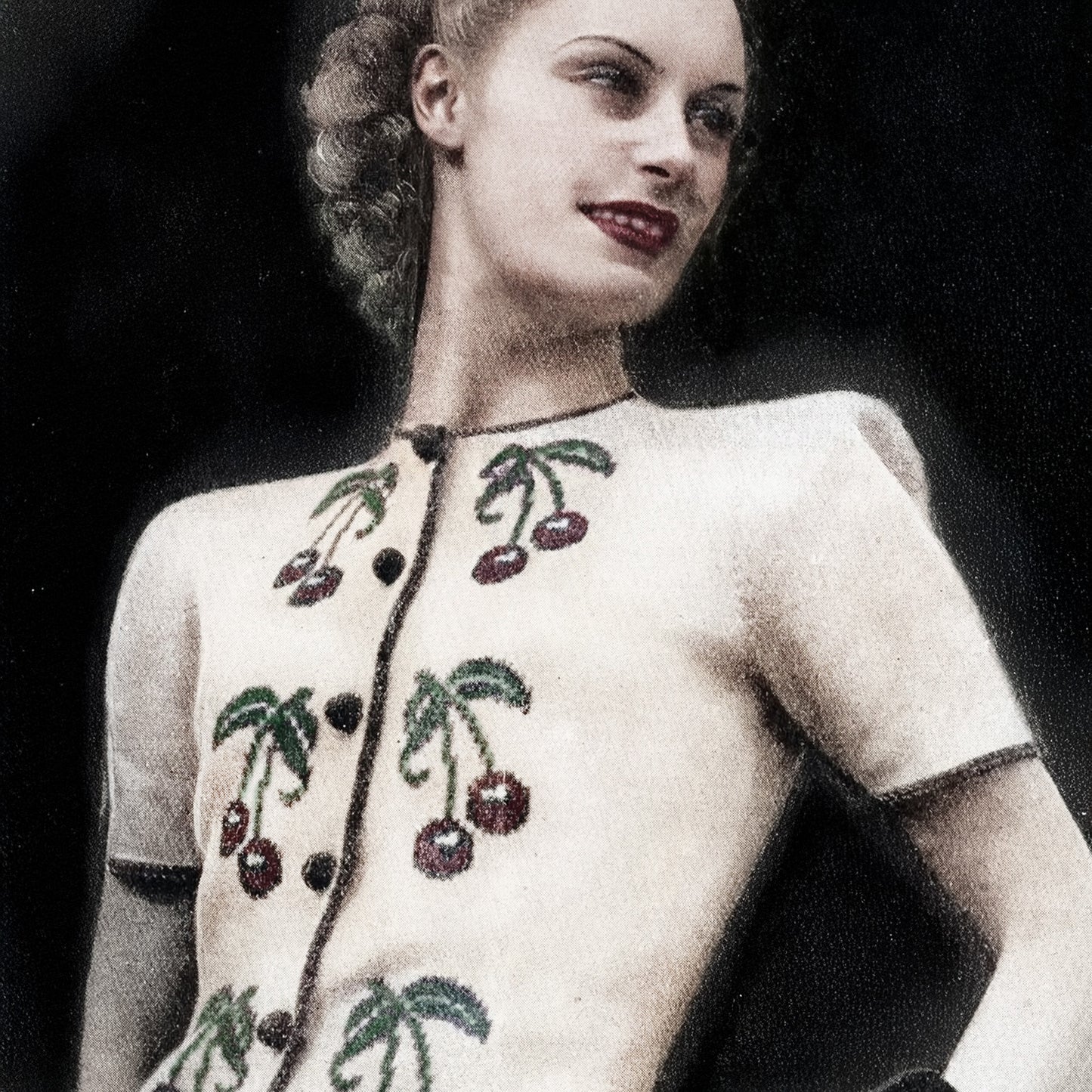 Vintage 1940s sweater with cherry design on a plain background