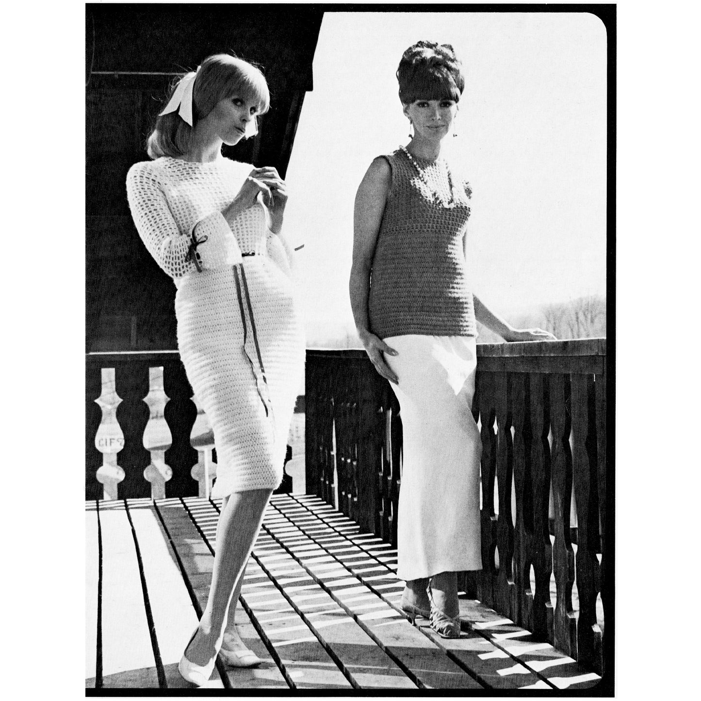 Two women standing on a wooden deck, wearing vintage clothing.