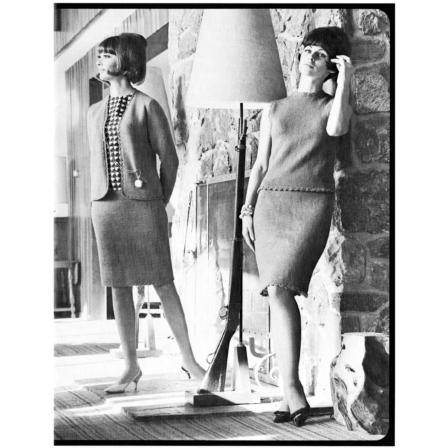 Two women in vintage knitted skirt suits standing against a stone wall.