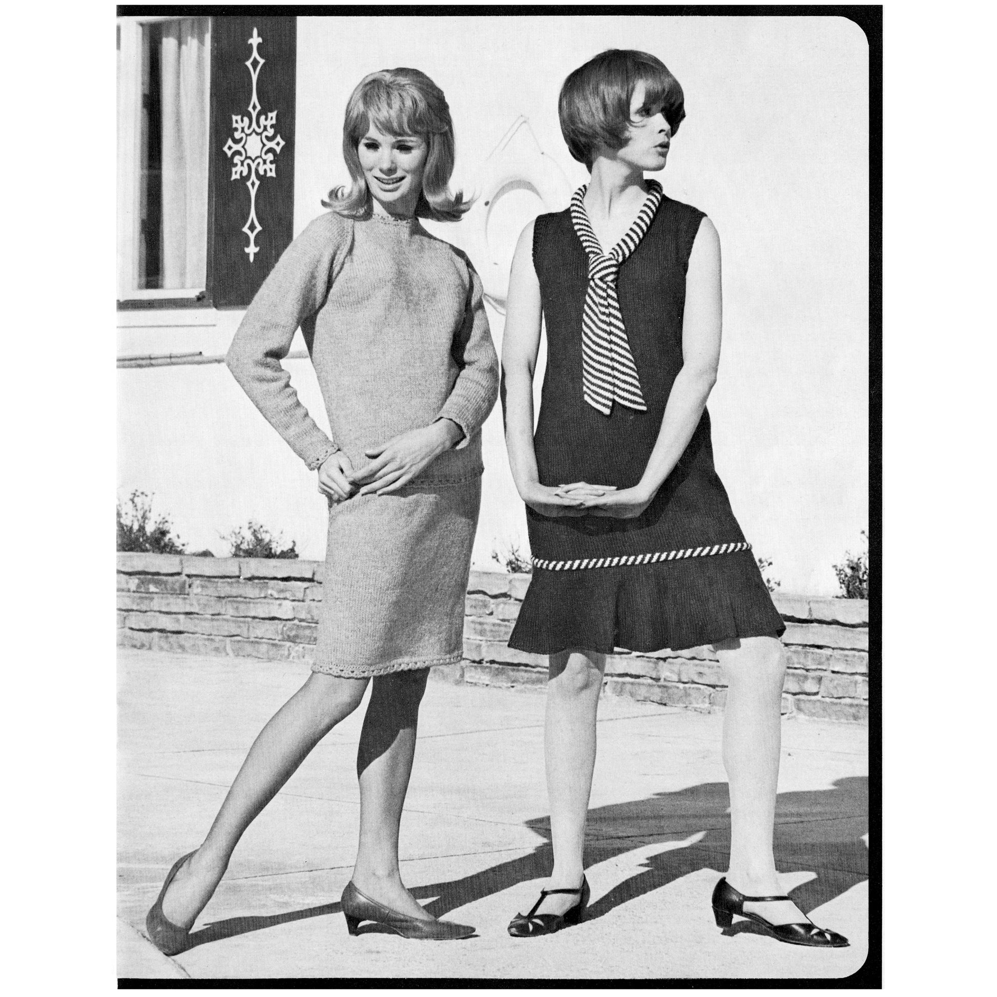 Two women in vintage knitted dresses standing outdoors with a building in the background.